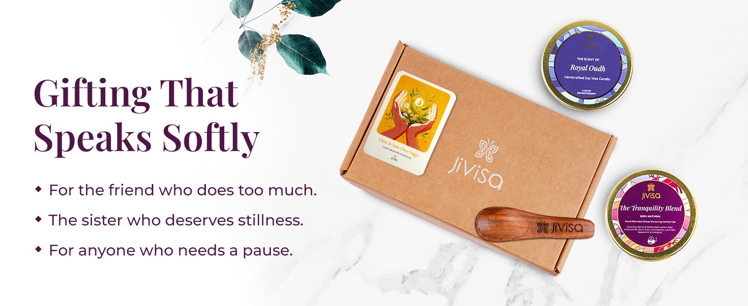 Flat lay of JiViSa Tranquil Himalayan Gift Box with affirmation card, JiViSa Royal Oudh candle tin, JiViSa  Tranquility herbal tea Blend tin, and JiViSa  wooden spoon. Tagline the left reads: “Gifting That Speaks Softly” with bullet points: For the friend who does too much | The sister who deserves stillness | For anyone who needs a pause.