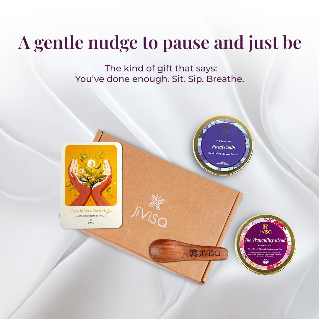 Tagline reads: "A gentle nudge to pause and just be – The kind of gift that says: You’ve done enough. Sit. Sip. Breathe" followed by a top-view arrangement of the kraft JiViSa Tranquil Himalayan Tea &amp; Candle Gift Box with its contents spread out: JiViSa Tranquility blend herbal tea tin, Royal Oudh candle tin, wooden spoon, and personalized handwritten gift card. The soft fabric background and circular layout evoke quiet luxury and mindfulness.