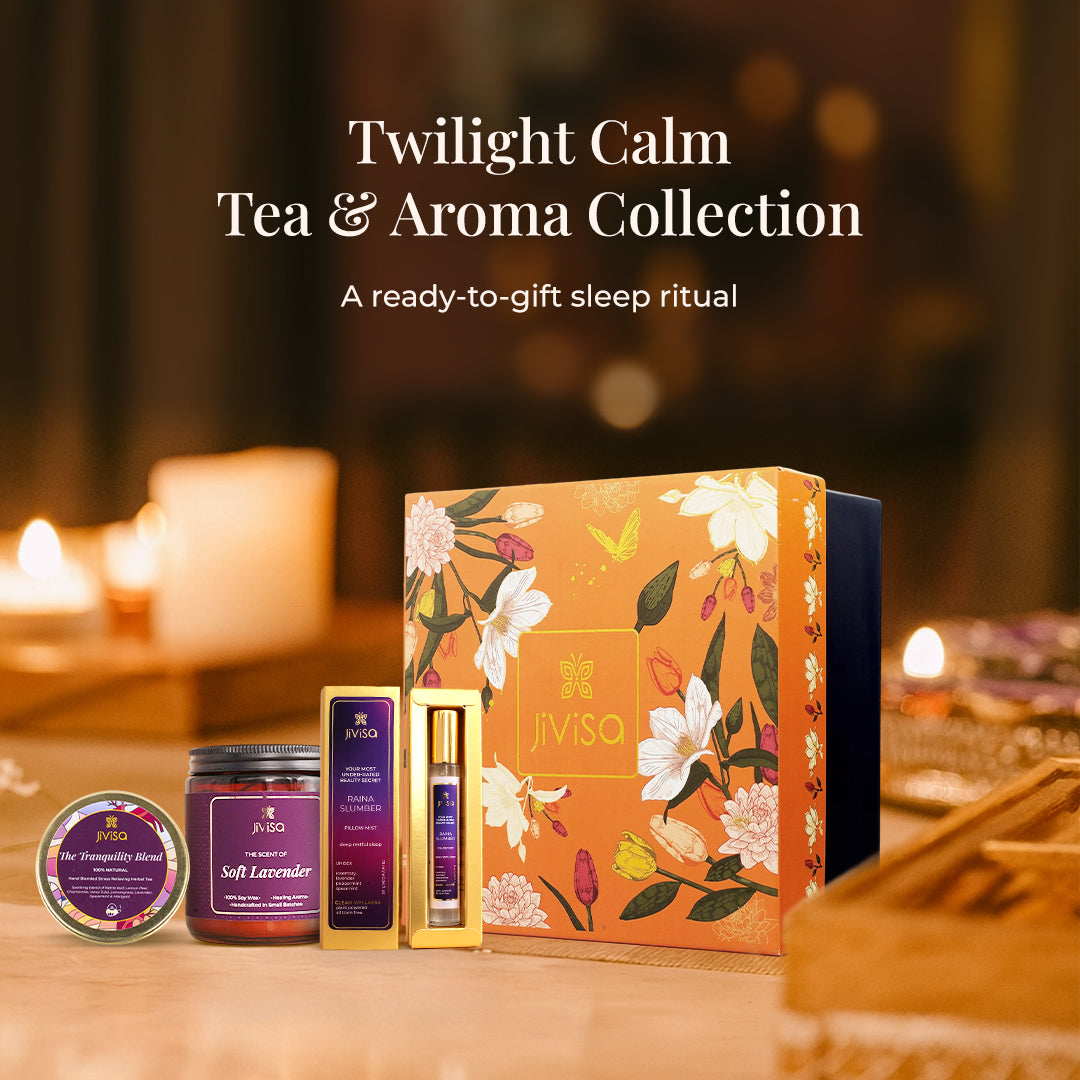 JiViSa Twilight Calm Tea &amp; Aroma Collection gift box, featuring a soft lavender soy wax candle glass jar, raina slumber pillow mist, and tranquility blend tea set in a cozy, dimly lit background with soft, blurred fairy lights and candles, creating a festive ambiance.