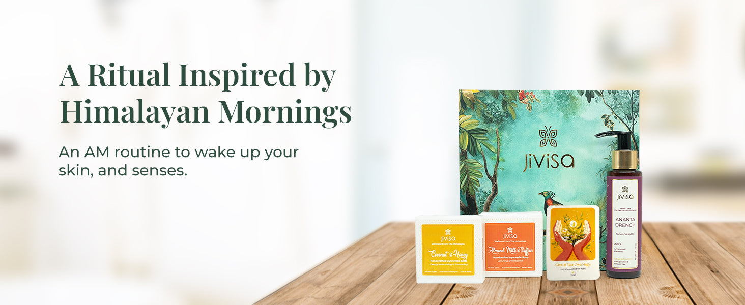 JiViSa Wake-Up Ritual Gift Box with Ananta Drench Facial Cleanser, Coconut & Honey Ayurvedic Soap, Almond Milk & Saffron Ayurvedic Soap, and a glow affirmation card, placed on a wooden surface next to a nature-inspired green gift box. Text on the left reads: “A Ritual Inspired by Himalayan Mornings.” Subtext: “An AM routine to wake up your skin, and senses.”

