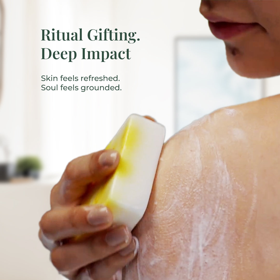 Close-up of a woman using JiViSa Ayurvedic soap on her shoulder. Visible lather and bright yellow soap in hand. Text overlay: “Ritual Gifting. Deep Impact.” Subtext: “Skin feels refreshed. Soul feels grounded.”
