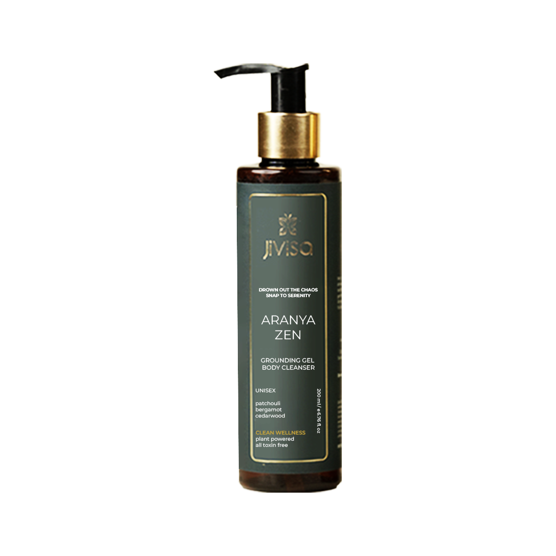 Front view of a Jivisa Aranya Zen Grounding Gel Body Cleanser bottle. The bottle is amber-colored with a teal label, featuring the product name, key ingredients (patchouli, bergamot, cedarwood), and the tagline 'Drown out the chaos snap to serenity'. The bottle has a pump dispenser.