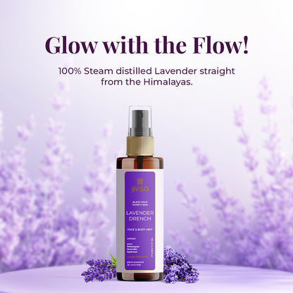 A bottle of JiViSa Lavender Drench Face &amp; Body Mist placed on a lavender-themed background with fresh lavender flowers. The label highlights it as a unisex, plant-powered, toxin-free mist made from 100% steam-distilled lavender from the Himalayas. Text above reads &
