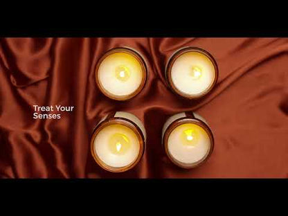 Thumbnail for a YouTube video titled “Treat Your Senses with Aromatherapy Soy Wax Candles | Holistic Himalayan Wellness.” It features a top view of four softly glowing JiViSa soy wax candles in amber jars arranged in a square pattern over rich brown satin fabric, with text on the left reads: “Treat Your Senses.”