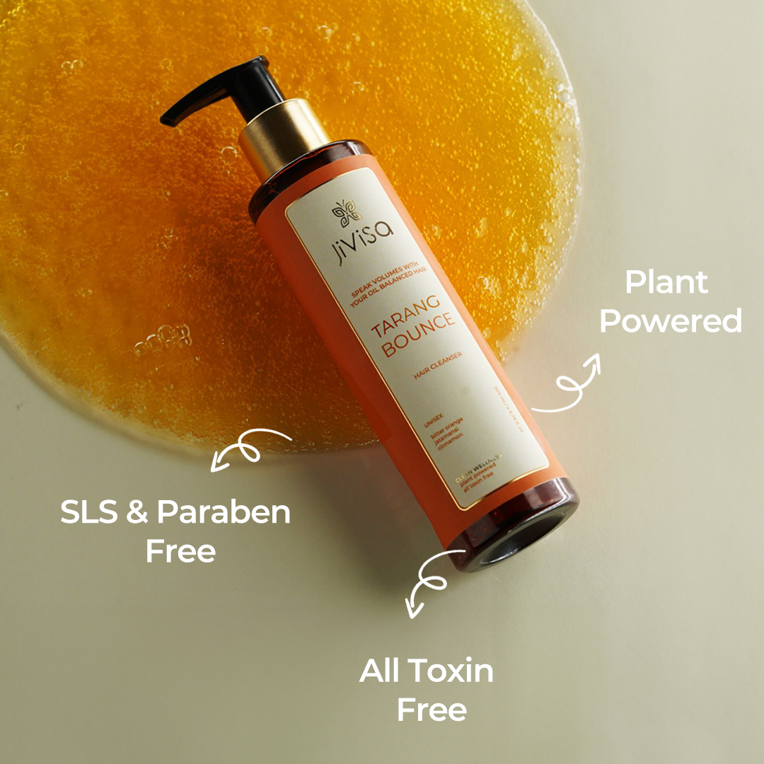 The image features a bottle of JiViSa Tarang Bounce Hair Cleanser lying on a pool of the product's gel. Text around the bottle highlights its features: "Plant Powered," "All Toxin Free," and "SLS & Paraben Free." The bottle label mentions key ingredients: bitter orange, jatamansi, and cinnamon.