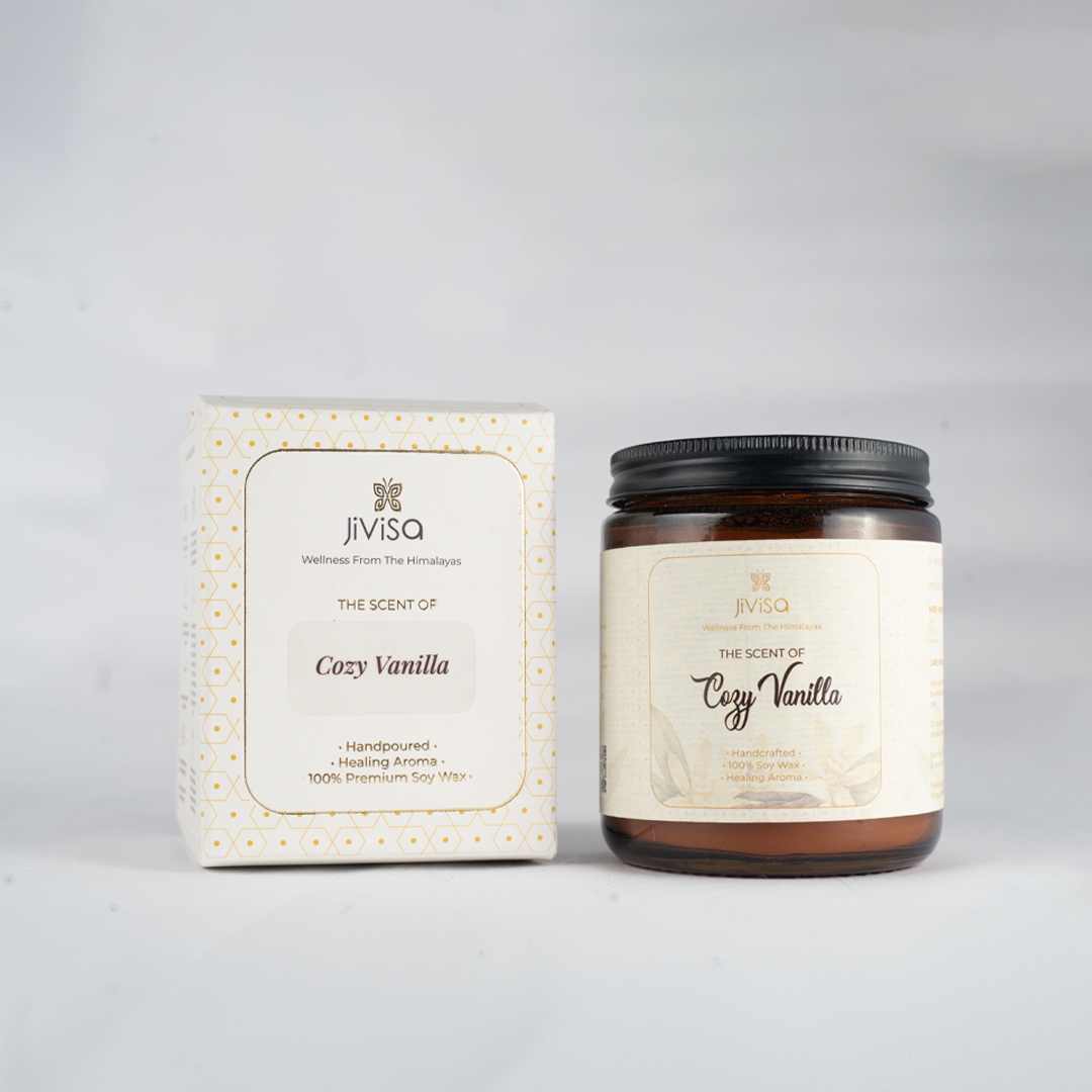 Image features both JiViSa Cozy Vanilla candle amber glass jar and its elegant white and gold-printed outer box against a soft beige background. The box and jar both label reads: &quot;JiViSa – The Scent of Cozy Vanilla – Aromatherapy Soy Wax Candle – Handpoured • Healing Aroma • 100% Premium Soy Wax.&quot;