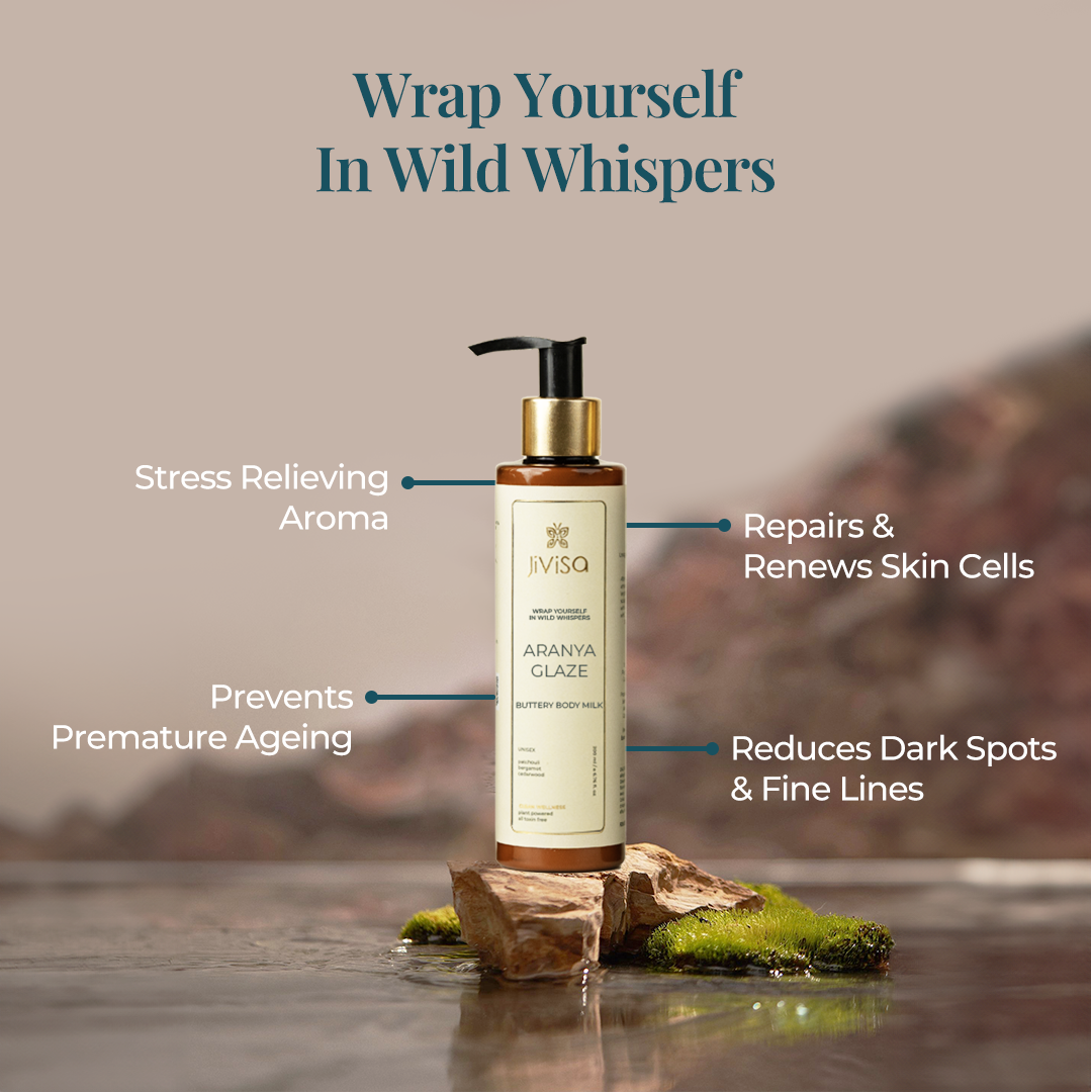 A Bottle of Jivisa's Aranya Glaze Buttery Body Milk Lotion with the text "Wrap Yourself In Wild Whispers." The benefits highlighted include Stress Relieving Aroma, Repairs & Renews Skin Cells, Prevents Premature Ageing, Reduces Dark Spots & Fine lines.