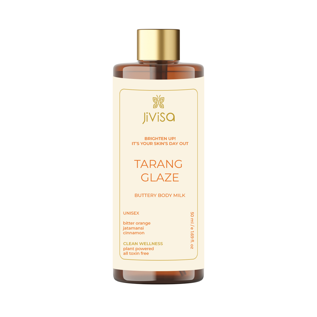 Front label of JiViSa Tarang Glaze Buttery Body Milk, 50ml bottle. The label showcases the product's name, 'Tarang Glaze,' and its tagline 'Brighten Up! It's Your Skin's Day Out.' It is a unisex body milk featuring ingredients like bitter orange, jatamansi, and cinnamon. The product promotes clean wellness, is plant-powered, and free of toxins. The label is designed in a vibrant orange color.