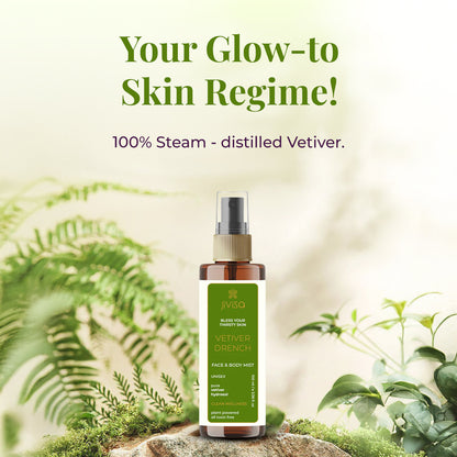 A bottle of JiViSa Vetiver Drench Face &amp; Body Mist is placed on a natural forest-like background with ferns and greenery. The label highlights it as a unisex, 100% steam-distilled vetiver hydrosol for clean, plant-powered all toxin free. The image features the text: &