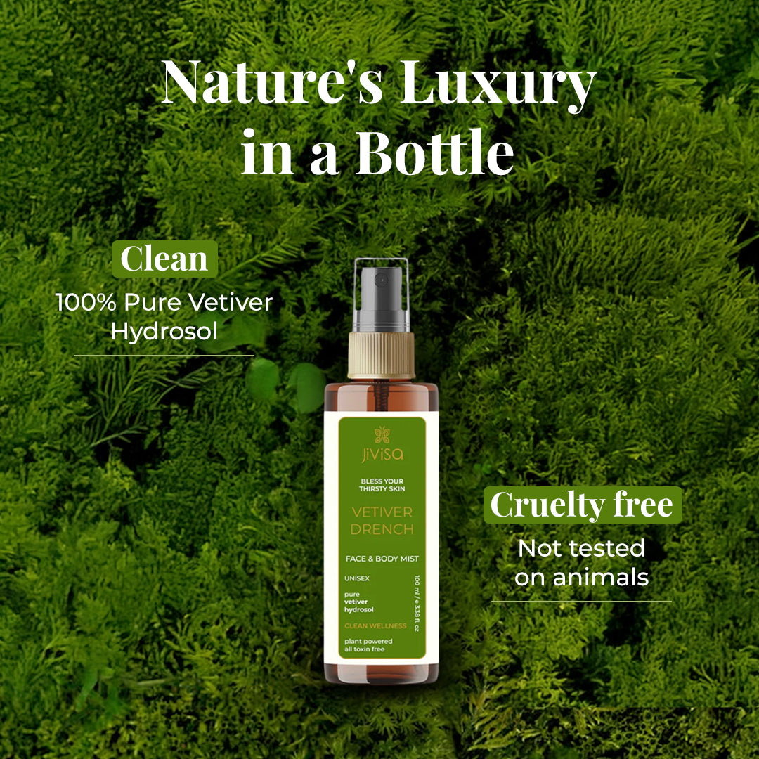 A bottle of JiViSa Vetiver Drench Face &amp; Body Mist is placed against a lush green botanical background. The label highlights it as a unisex, plant-powered mist made with pure vetiver hydrosol. On-image text reads: &